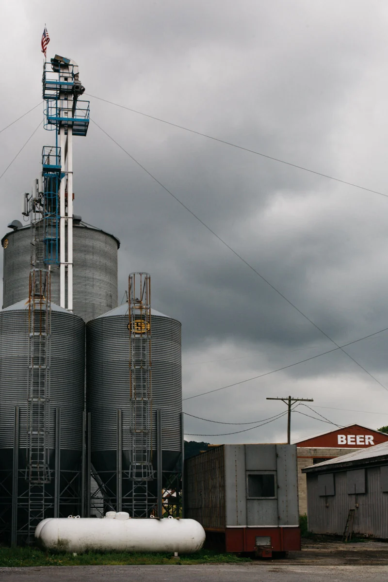Grain silos and a lattice tower under a heavy grey sky