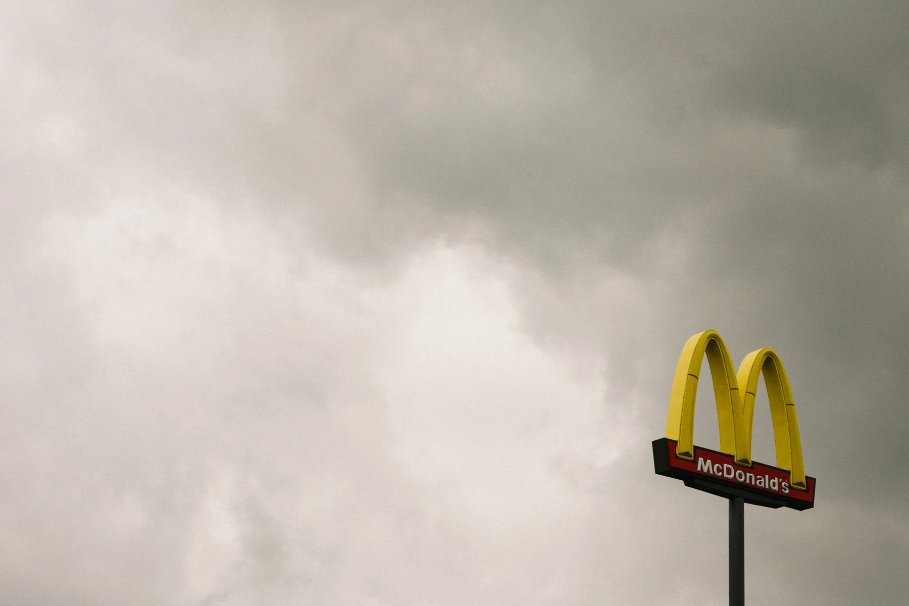 A McDonald's sign floating against an overcast sky