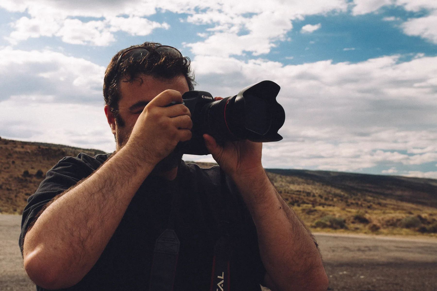 Taking a picture on the roadside with the cliffs behind