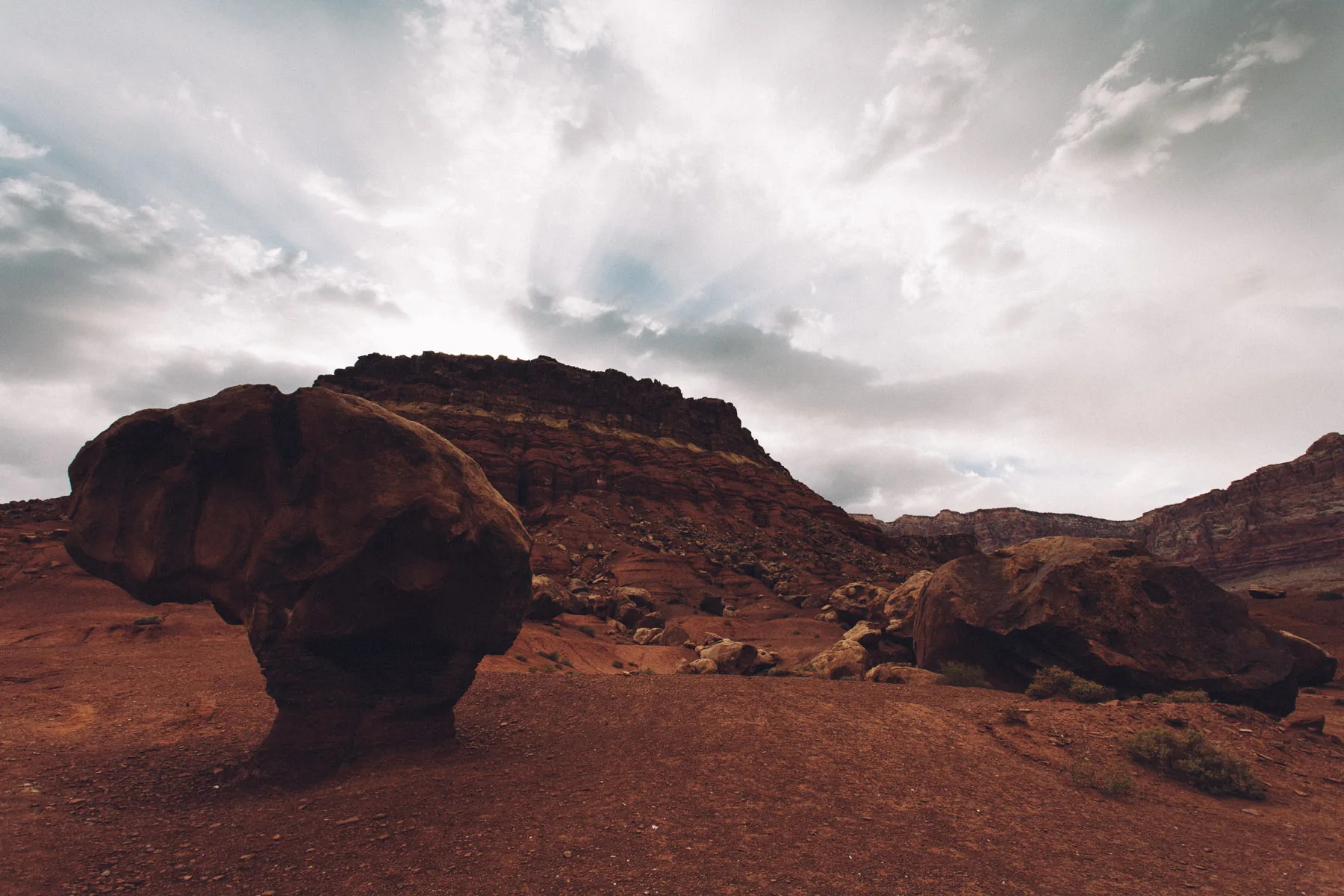 A balanced rock silhouetted against rays of light