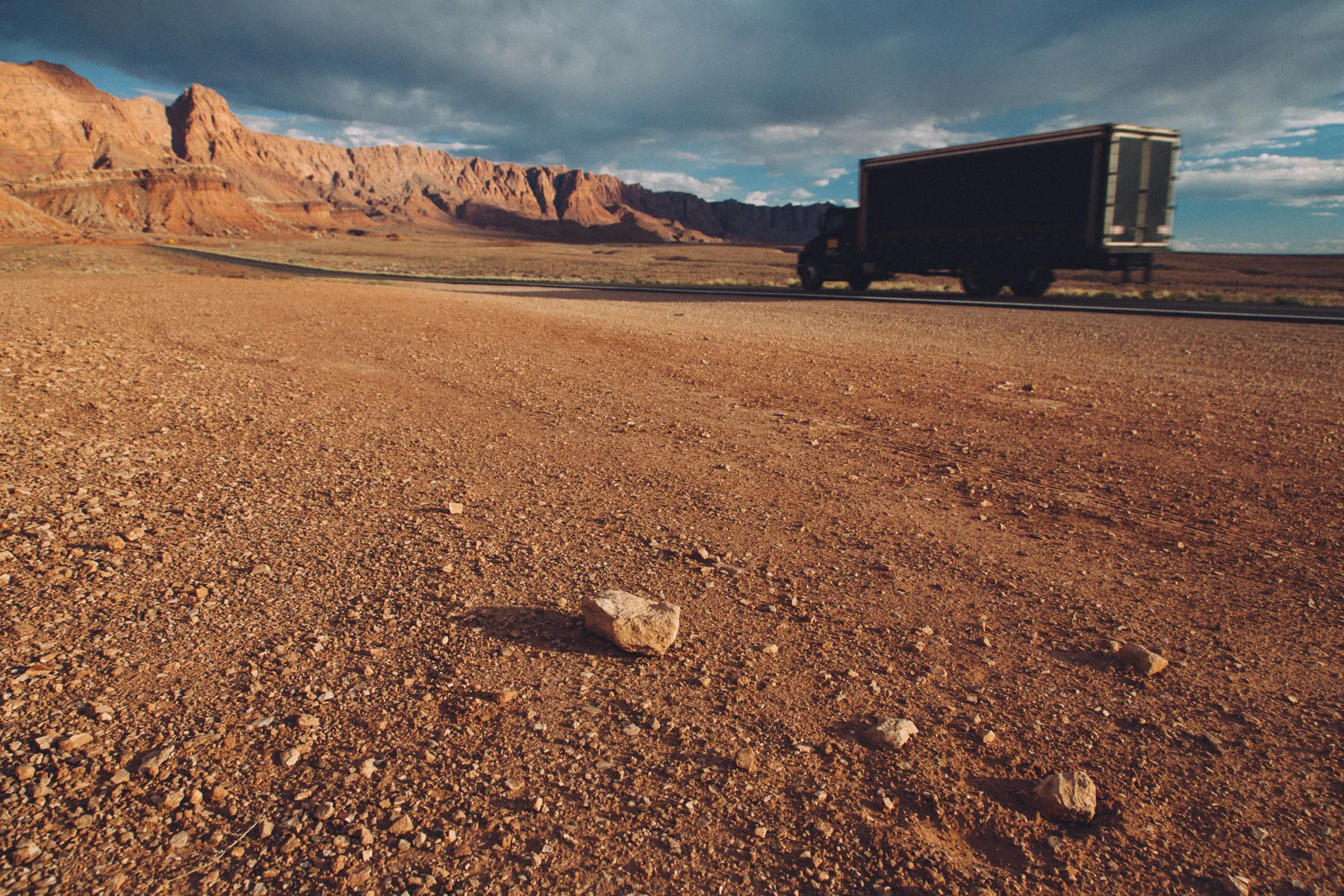A truck passing below the glowing cliffs