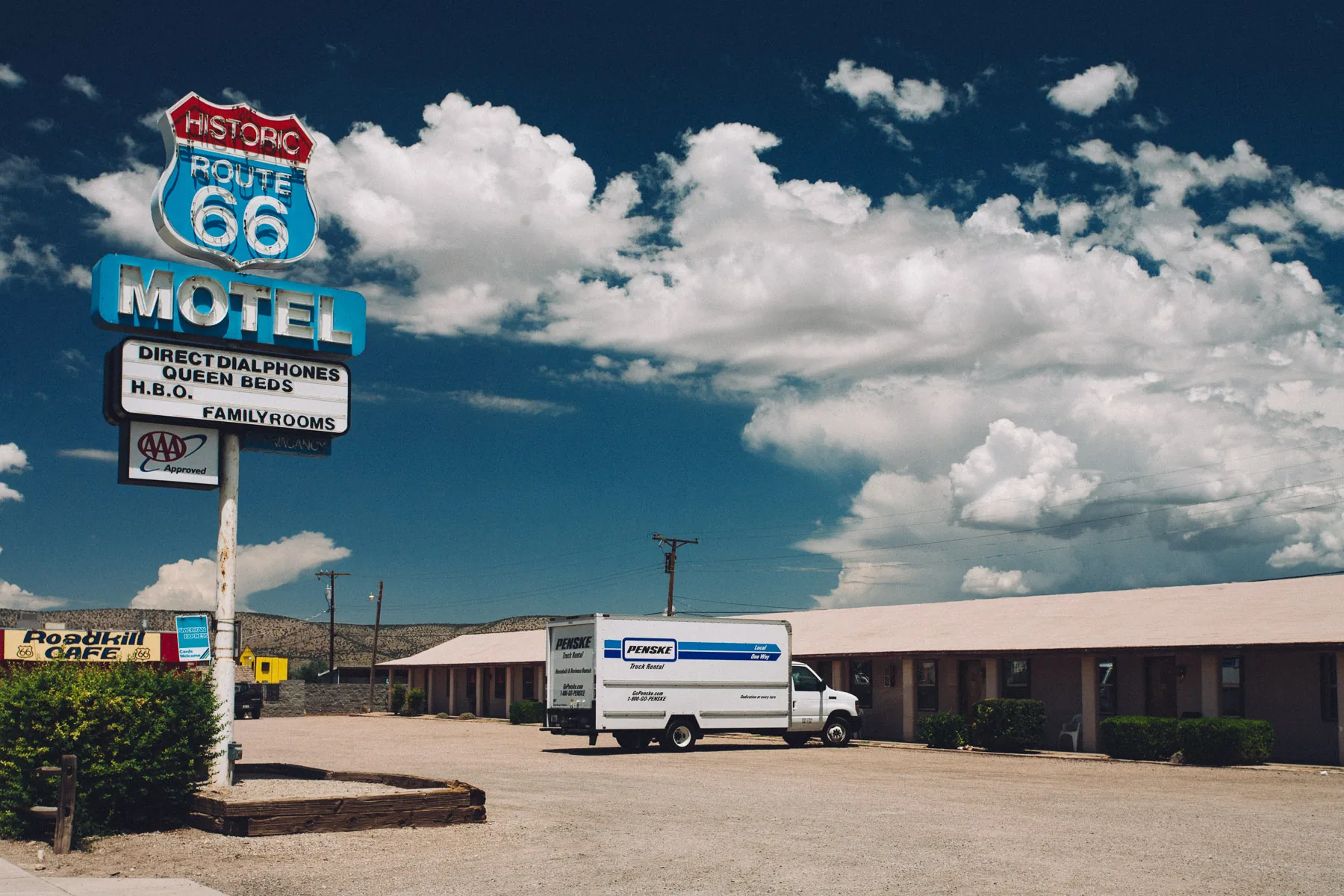A Historic Route 66 motel sign under big clouds