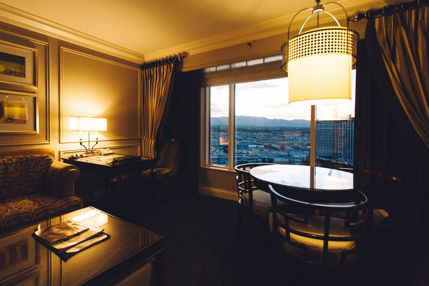 The suite's sitting area with a round table and hanging lamp by the window
