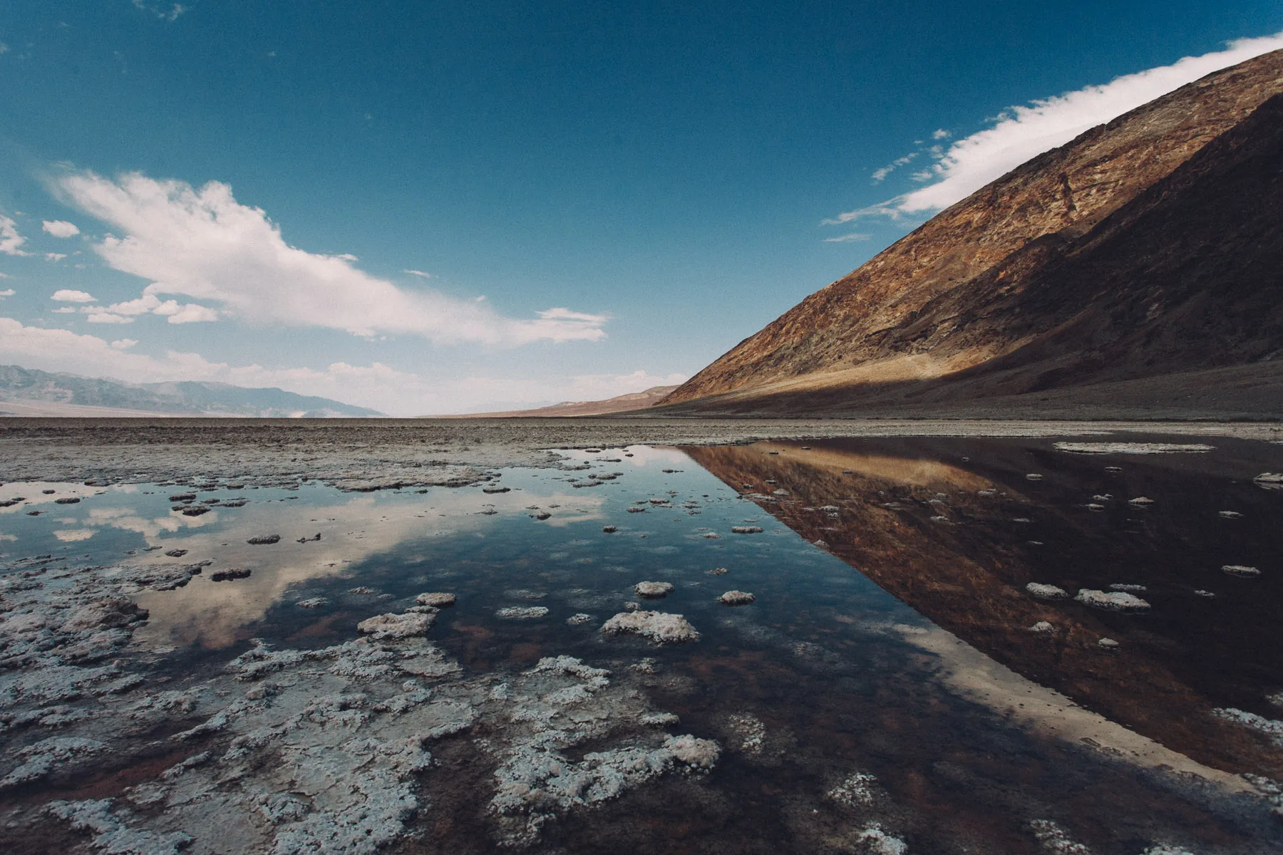 The sky and mountain reflected in the shallow pool at Badwater
