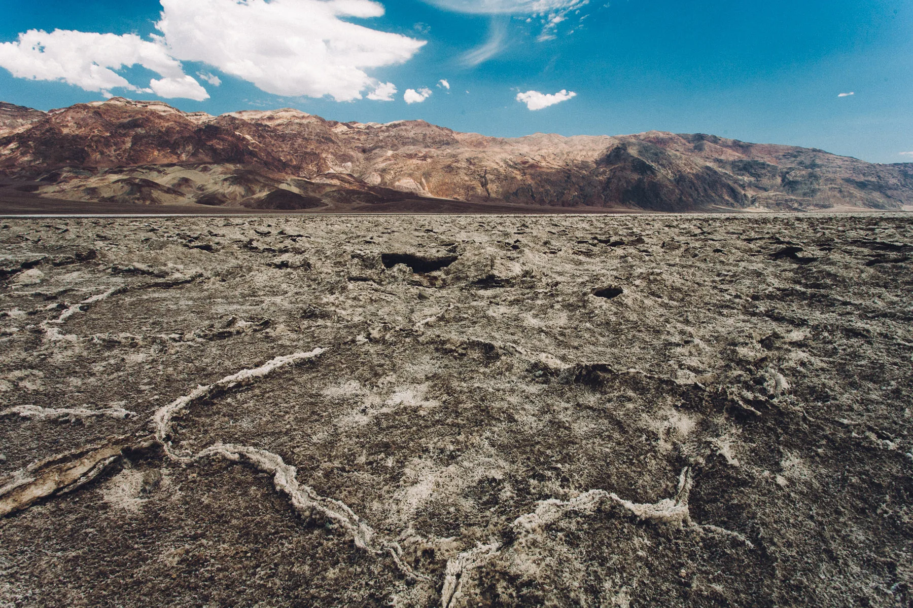 Cracked salt crust stretching to the mountains