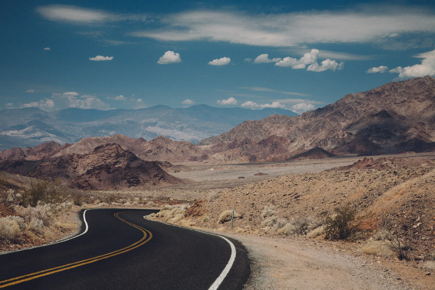 A winding road descending through the colorful hills