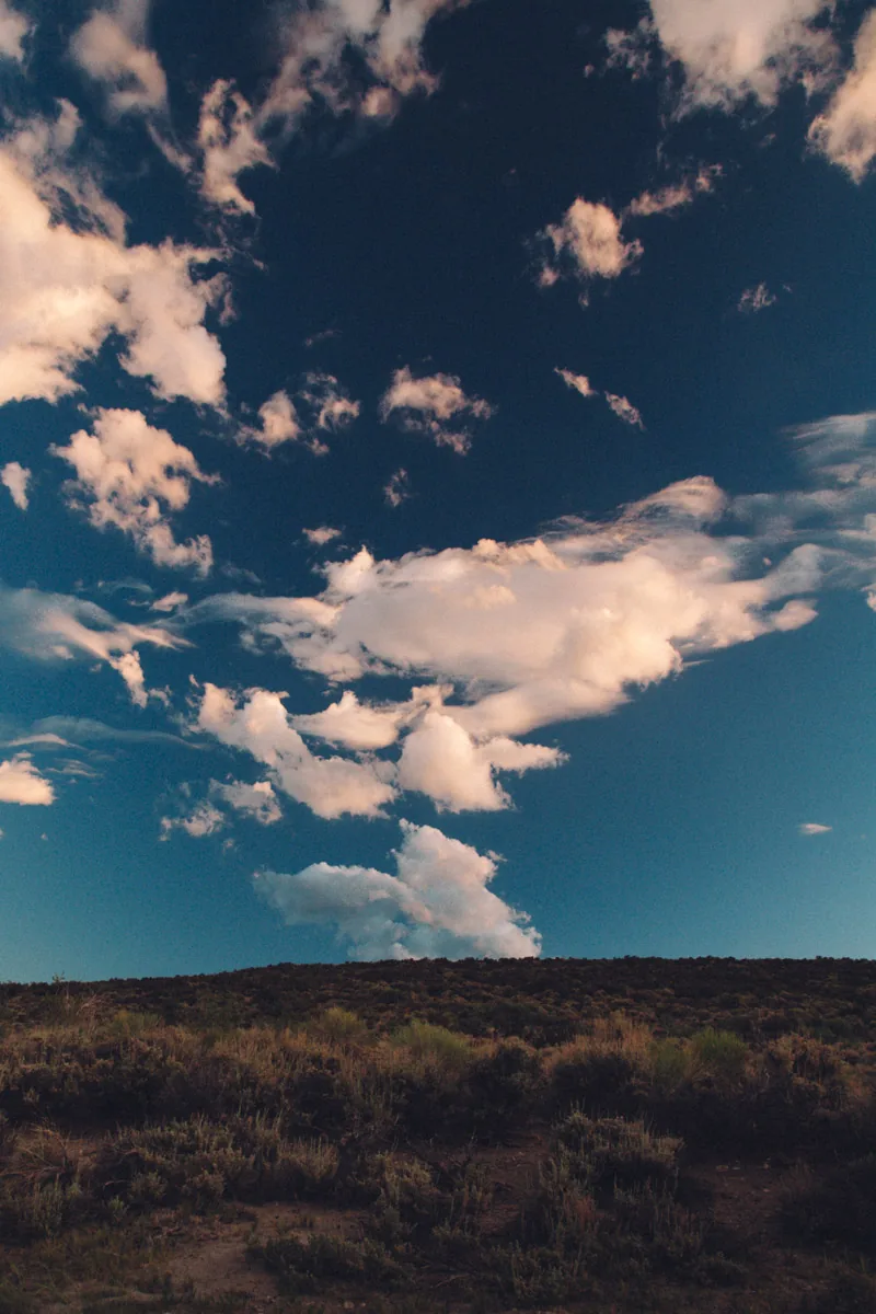 Clouds against a deep blue sky above the hills