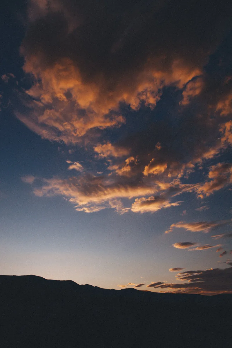 Glowing clouds above a dark ridge
