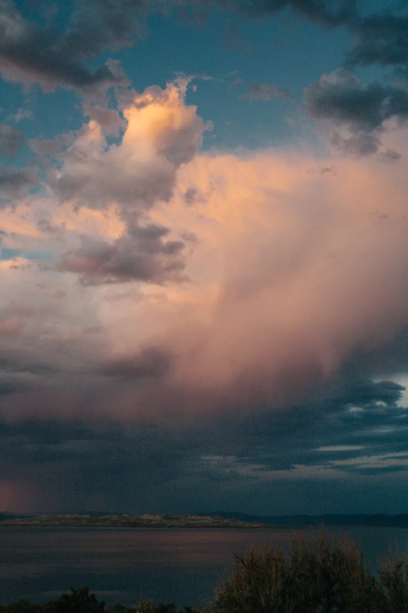 A rain shower under a glowing cloud over the lake