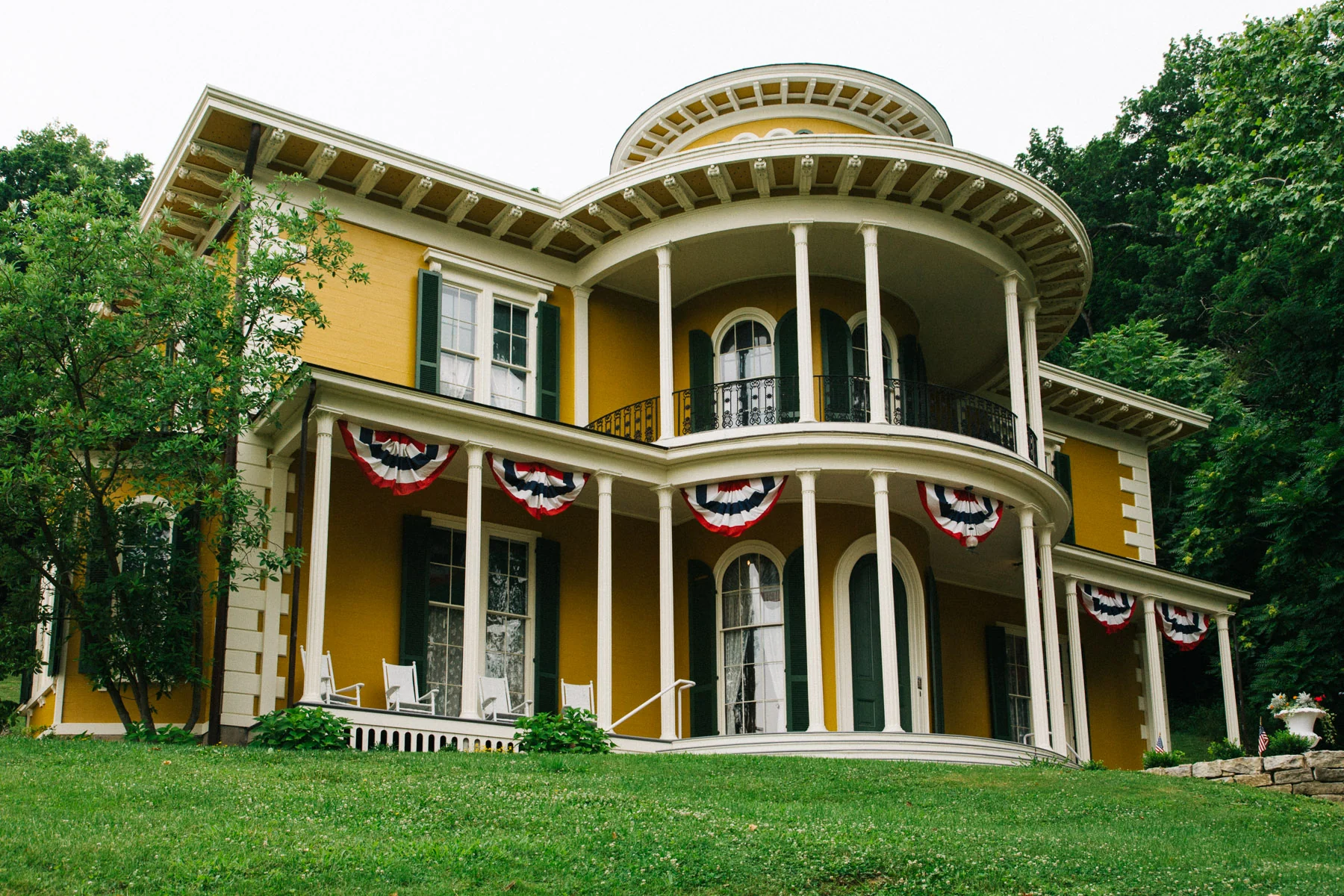 The yellow Hillforest House Museum with its rounded porches and Fourth of July bunting