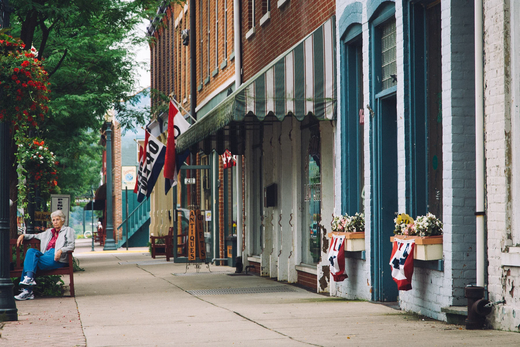Main Street in Rising Sun, with flags and benches along the shops