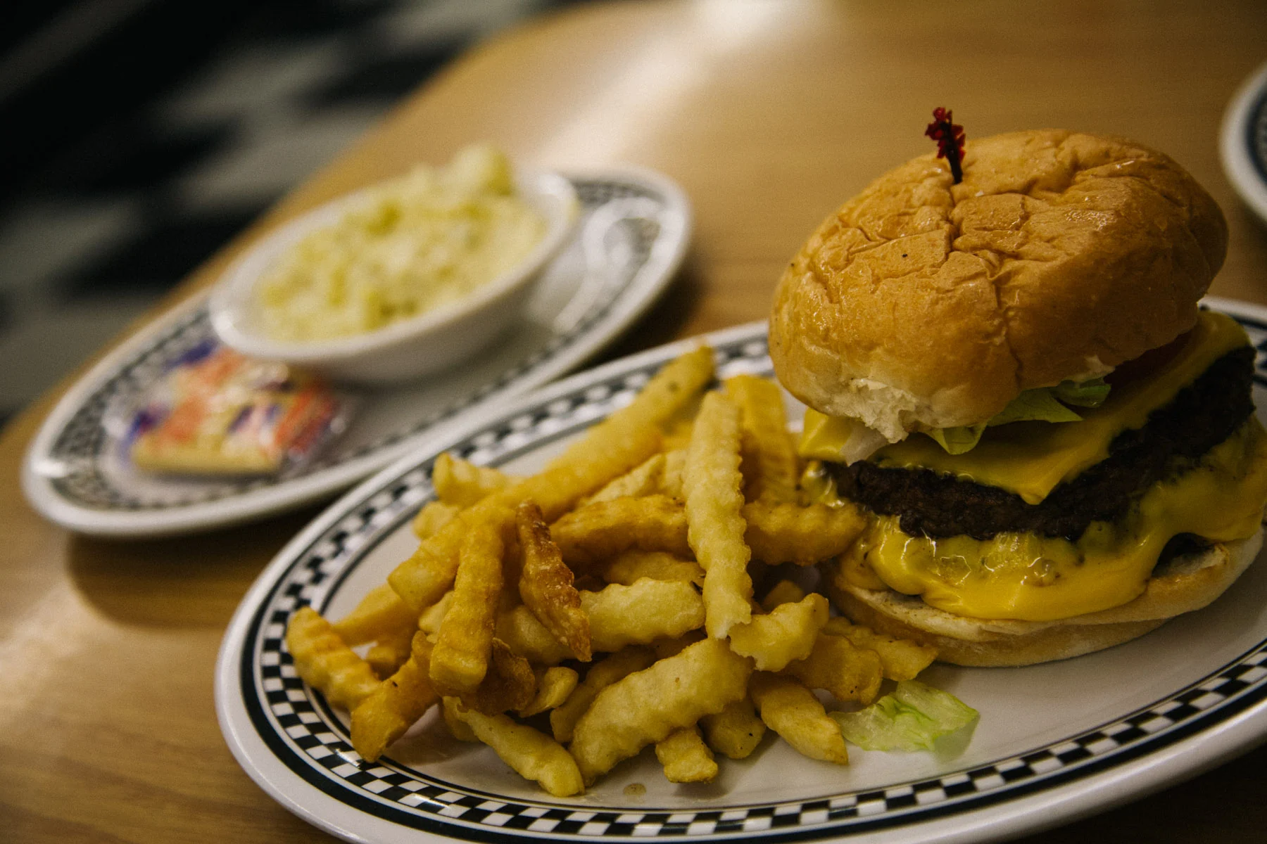 A burger and fries on a checked plate