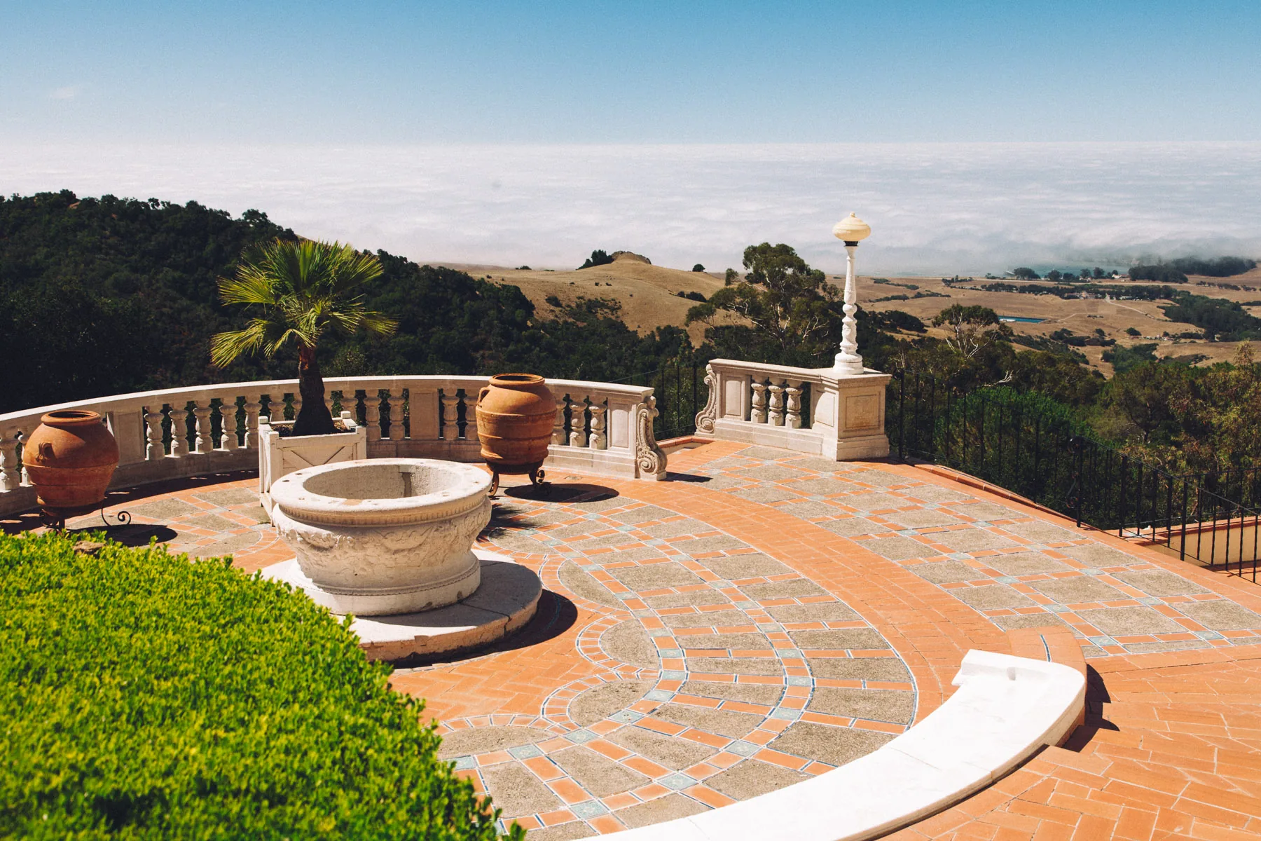A terrace with a fountain overlooking the hills and the sea of clouds