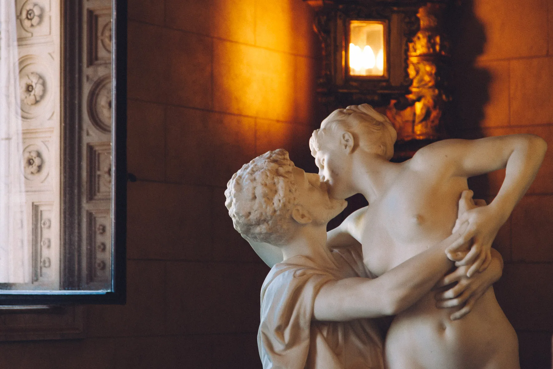 A marble statue of two lovers lit by a lantern