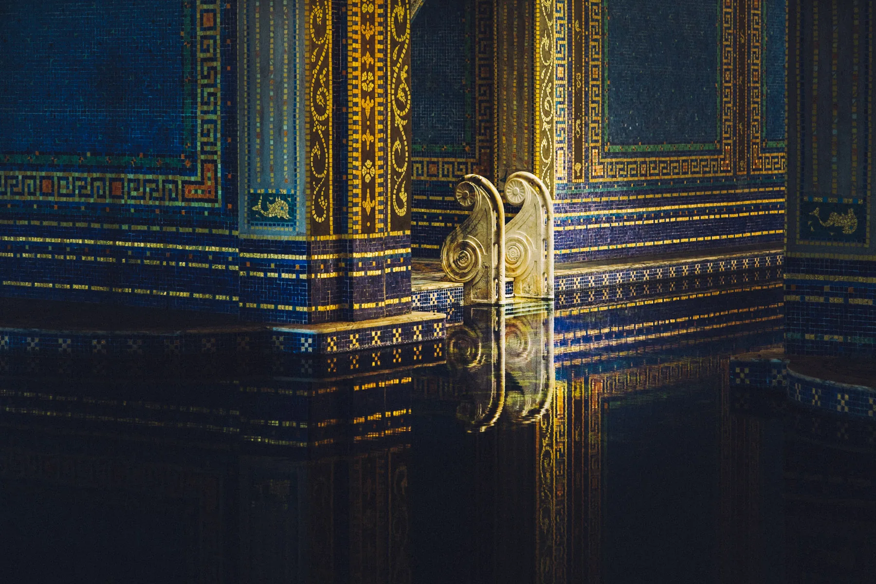 Gold mosaic columns reflected in the Roman Pool