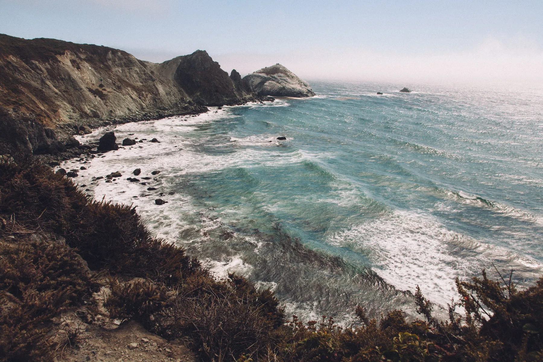 Waves breaking into a cove below the cliffs