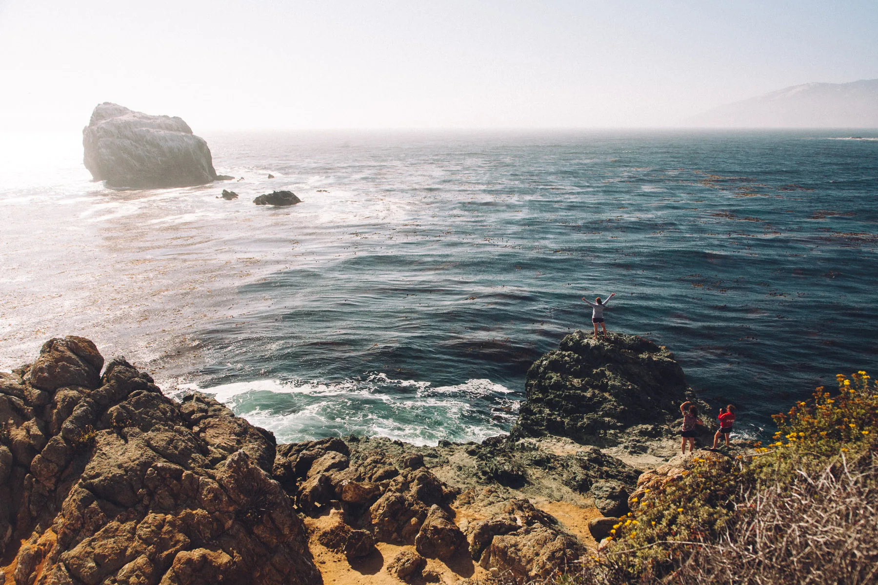A small figure on the rocks above the ocean
