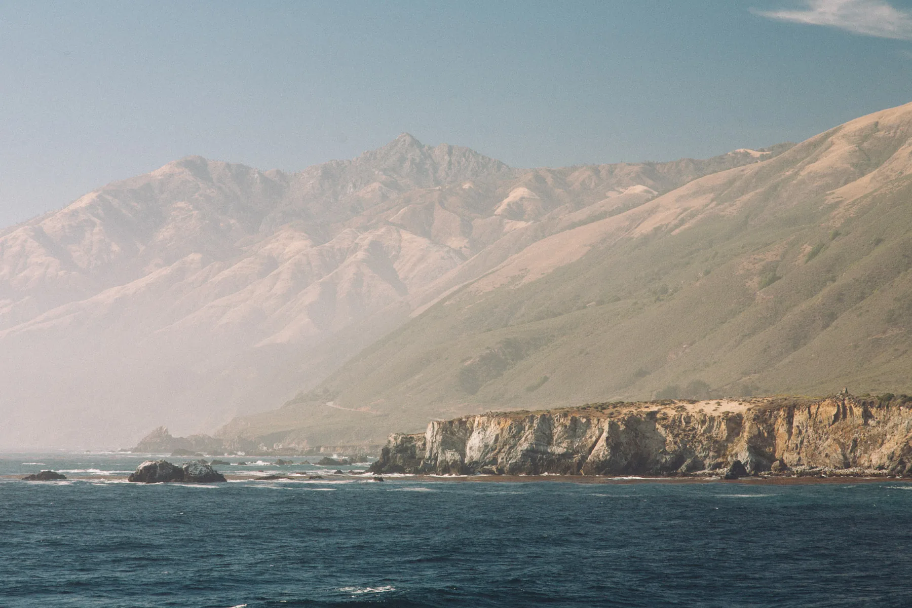 Hazy mountains dropping to the sea