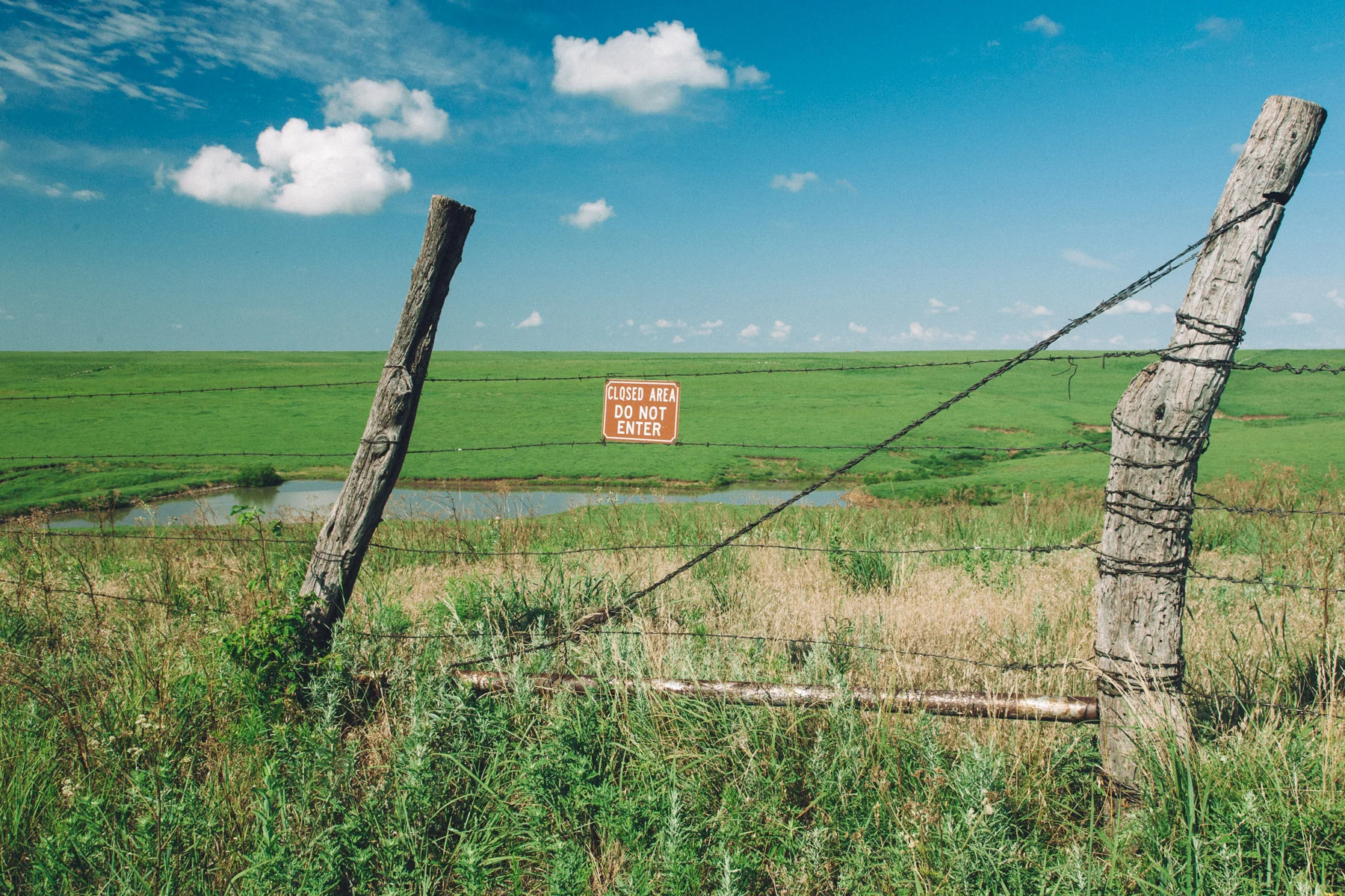 Old fence posts and barbed wire in the prairie grass