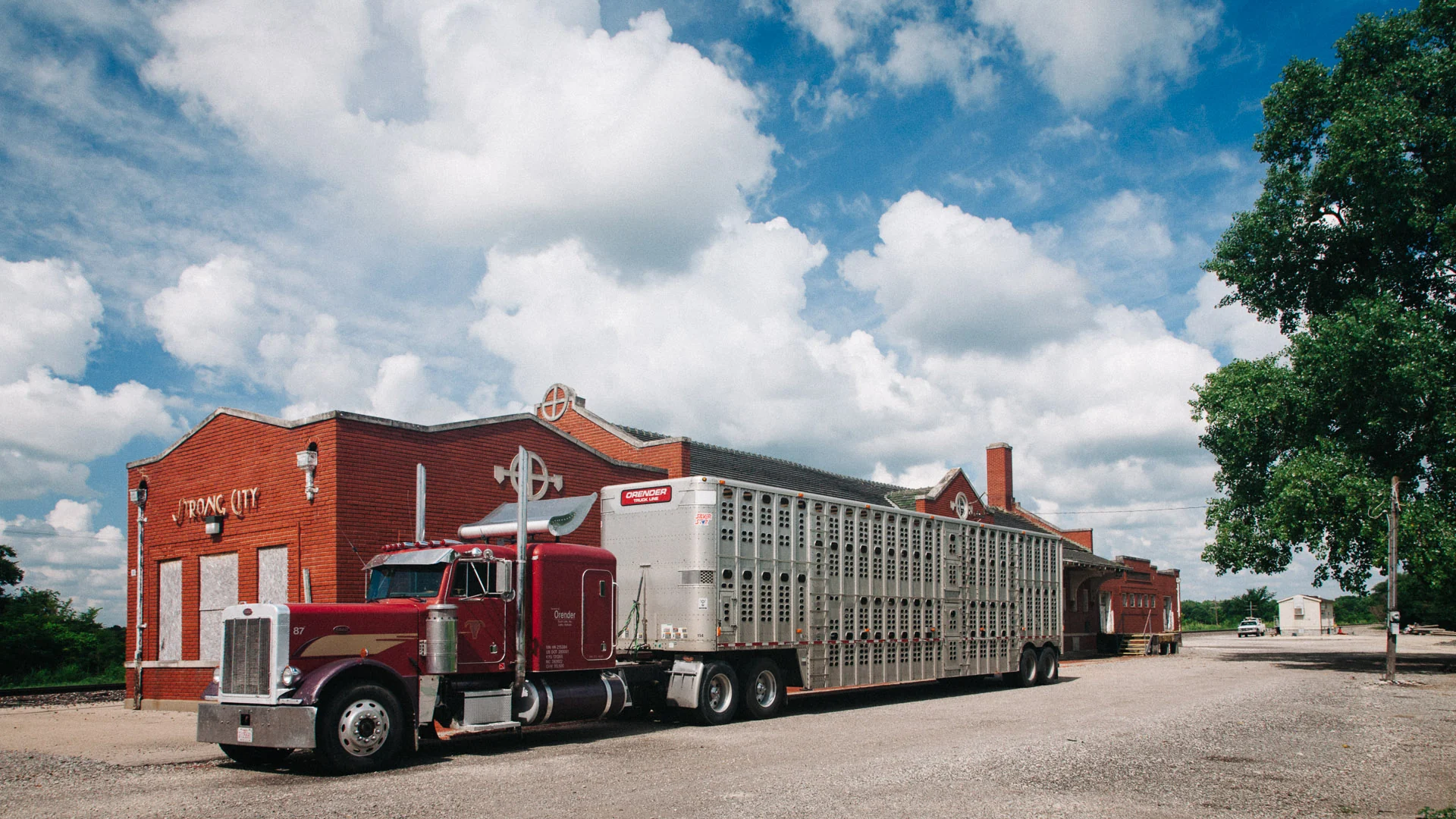 A red truck in front of the old railroad depot in Strong City