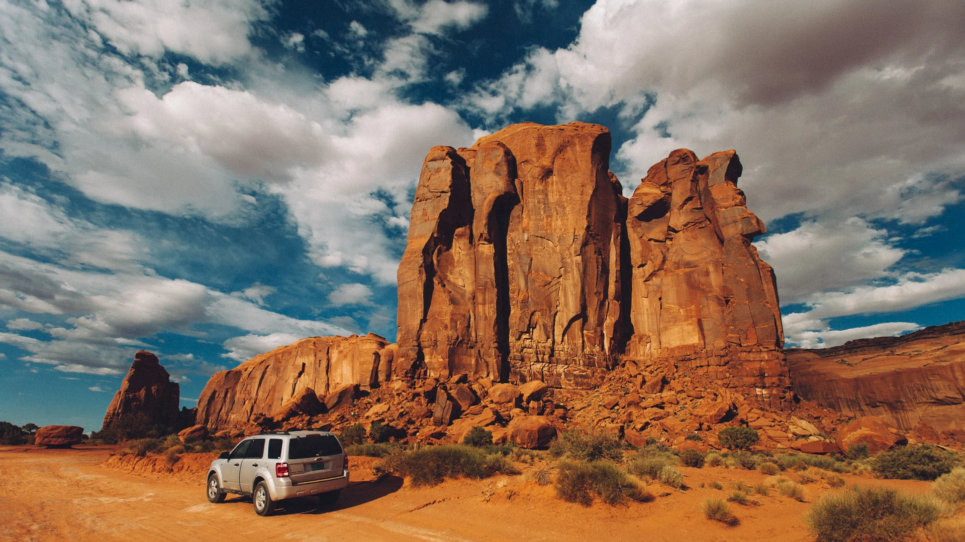 A huge butte towering over a passing car