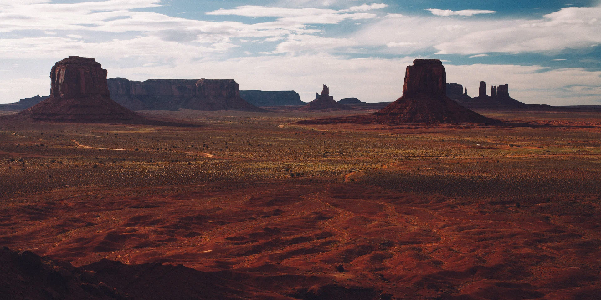 Buttes in shadow under a darkening sky