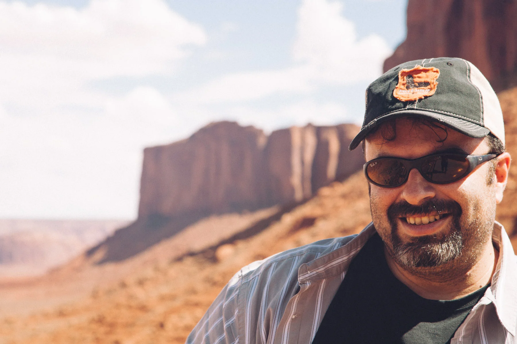 Francesco smiling in a cap, with red buttes behind