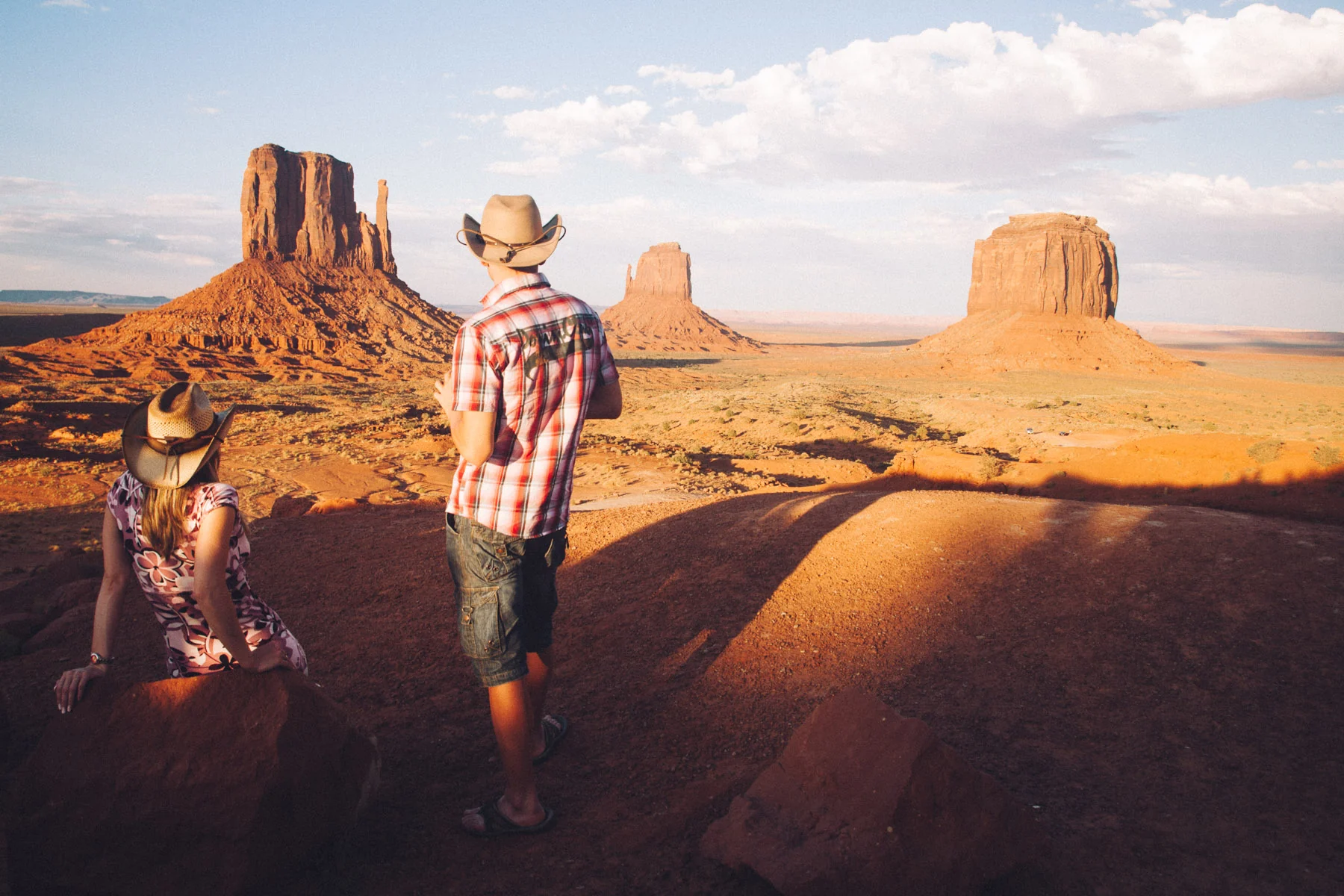 A newlywed couple in cowboy hats photographing the Mittens