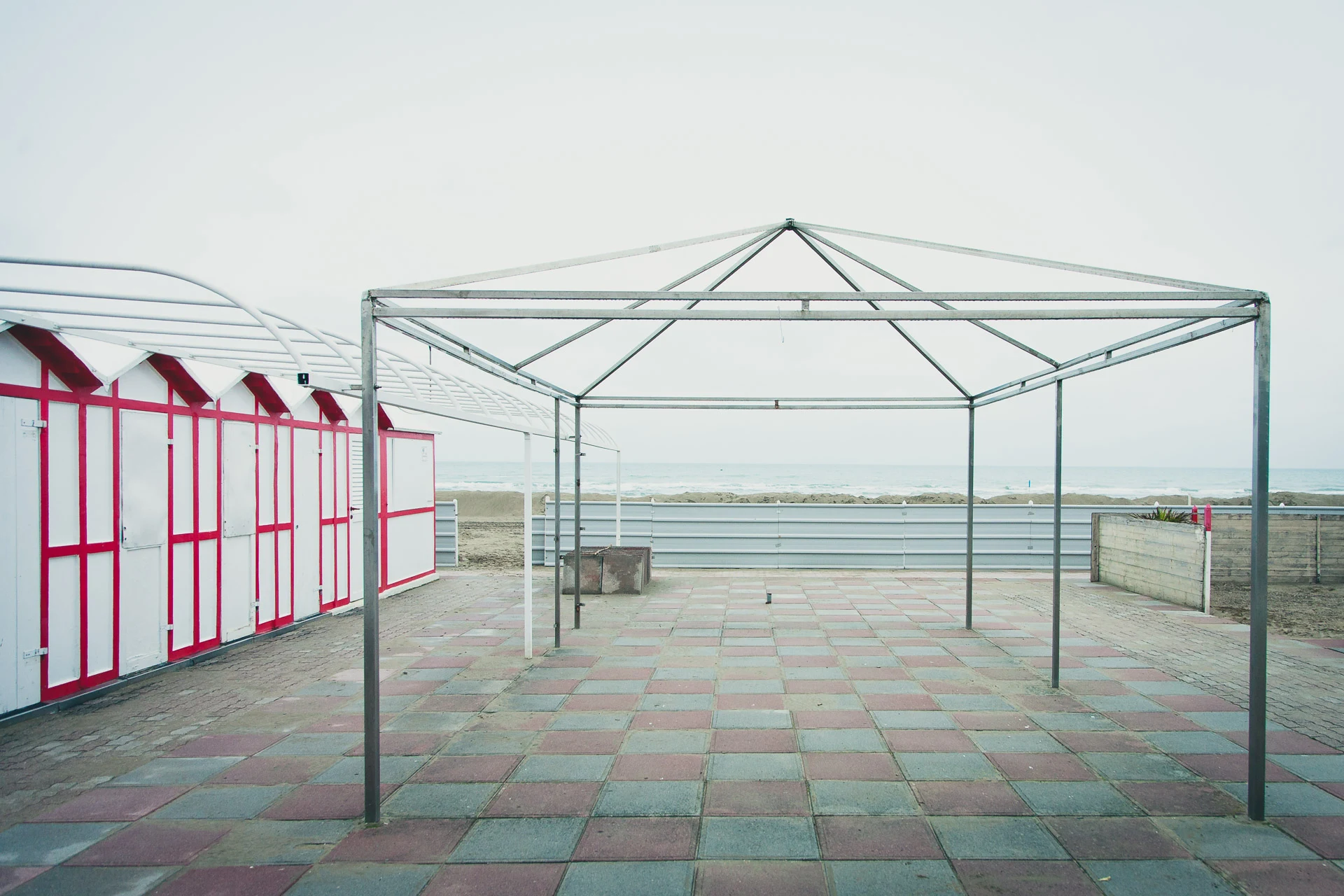Empty canopy structure beside red and white cabins