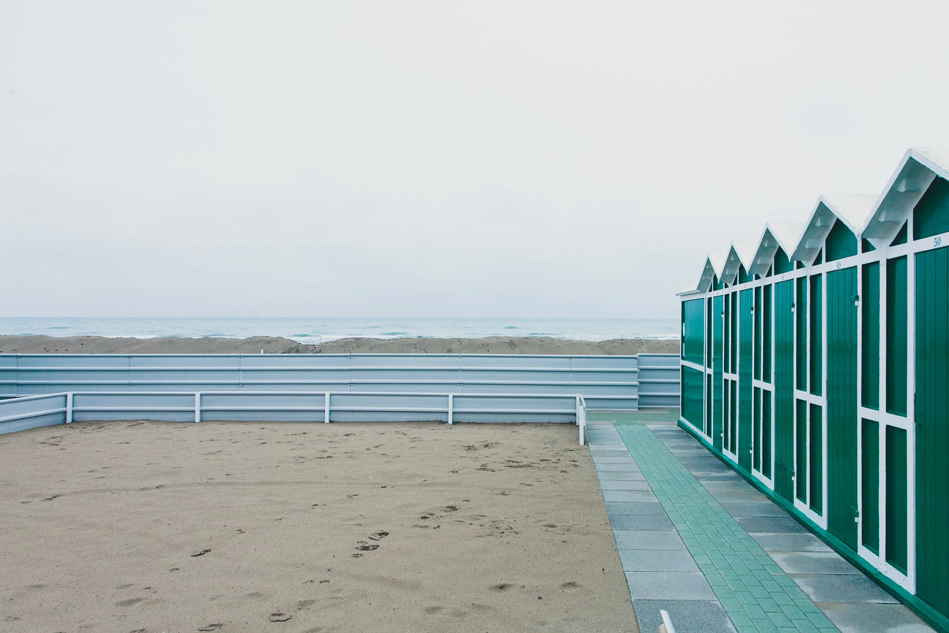 Green beach cabins and a pale winter sea