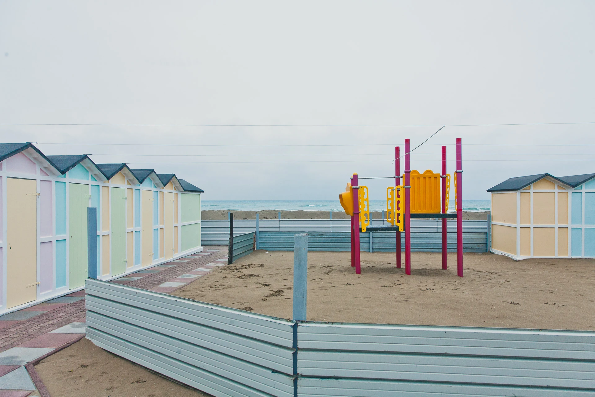 Empty beach playground surrounded by pastel cabins