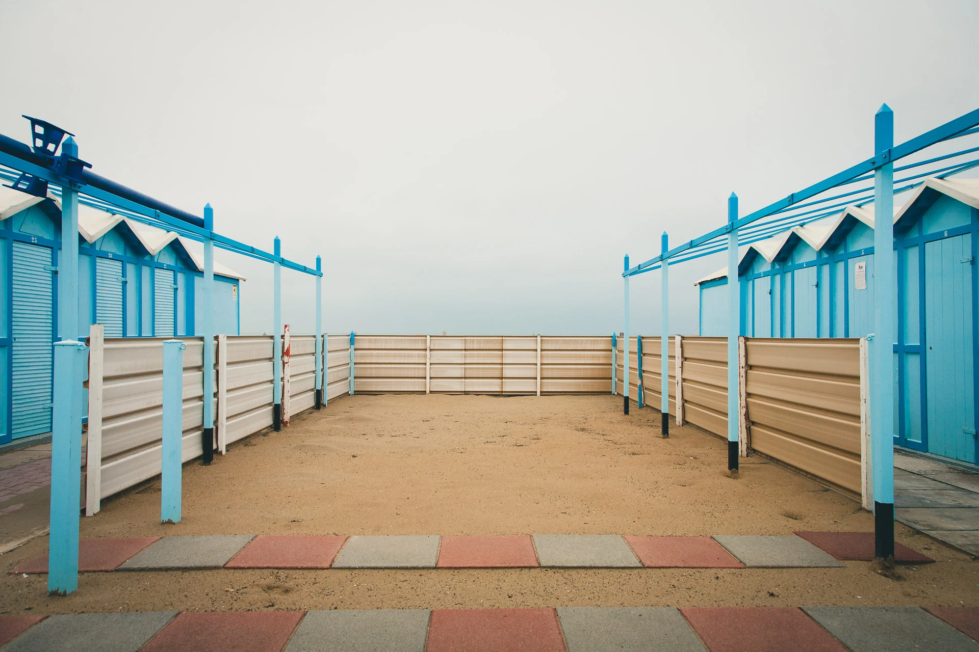 Blue cabins around a sandy courtyard