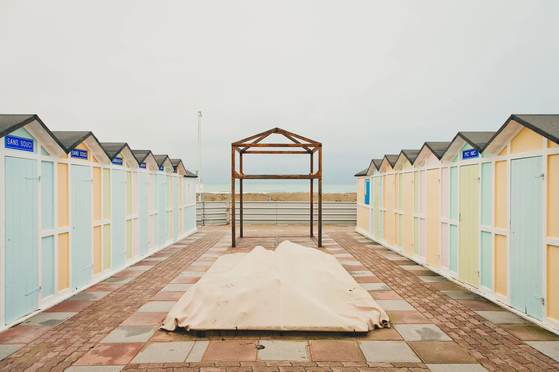 Pastel cabins framing an empty sandy passage