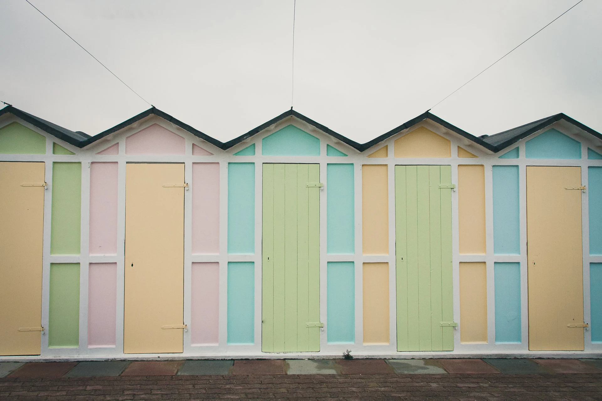 A row of closed pastel beach cabins