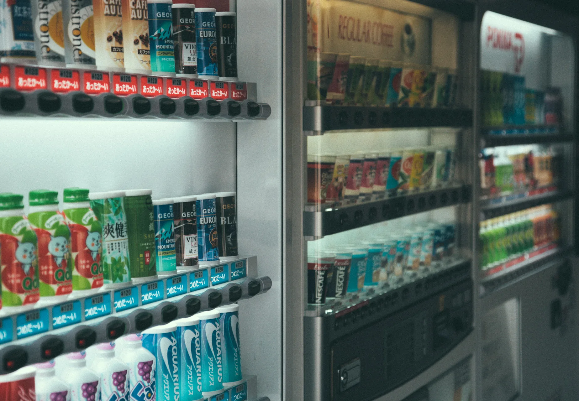 Rows of drinks in a brightly lit Japanese vending machine