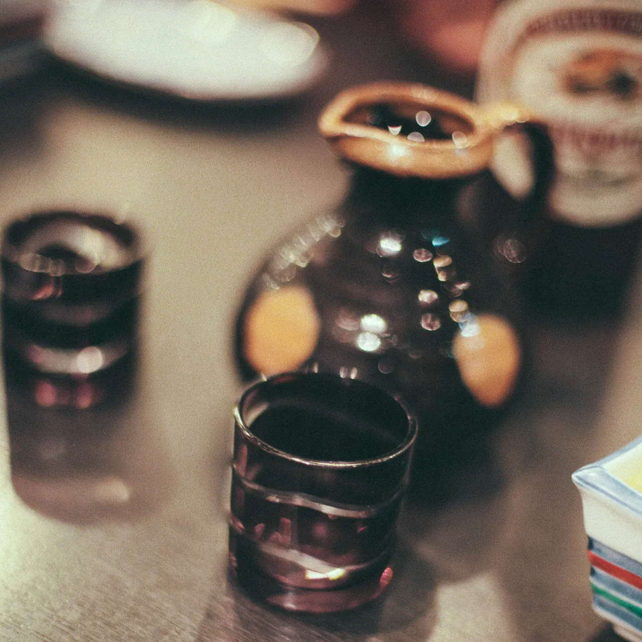 A sake flask and small cups on the table