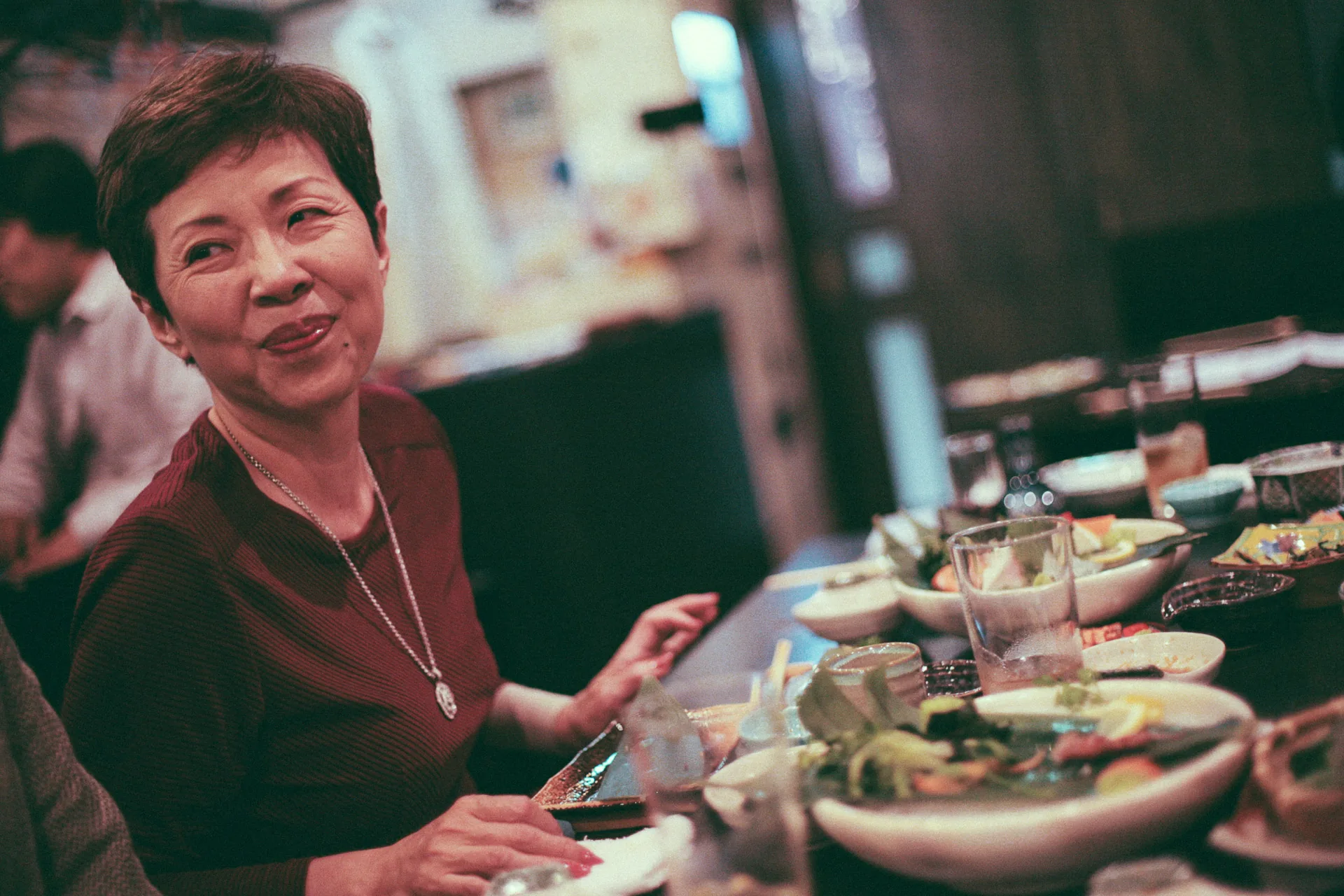 Smiling across the table full of dishes