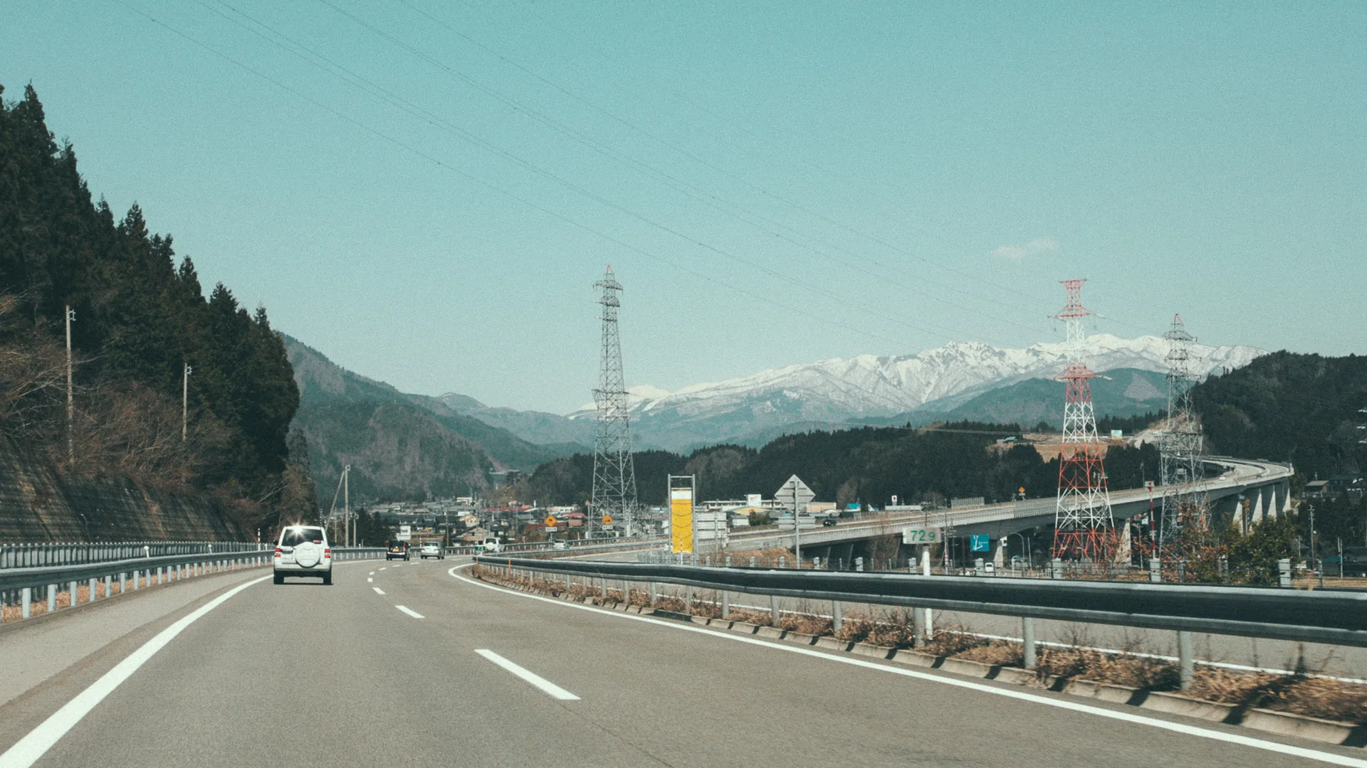 The expressway heading north toward snowy mountains