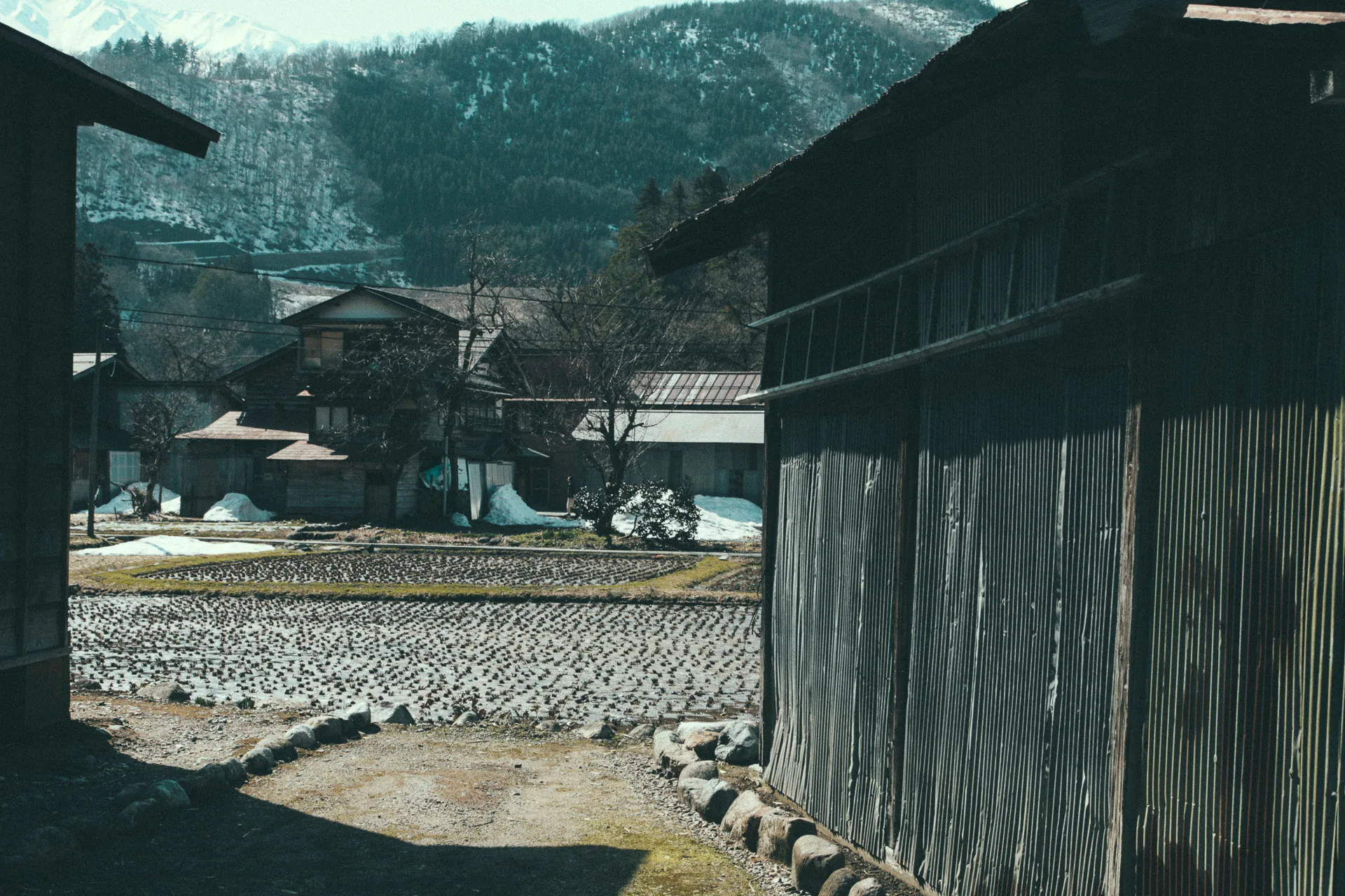 Wooden buildings framing a view of the village