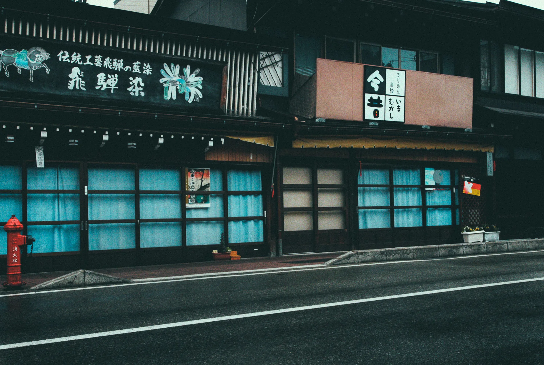 A traditional shop with blue windows on an empty street at dawn