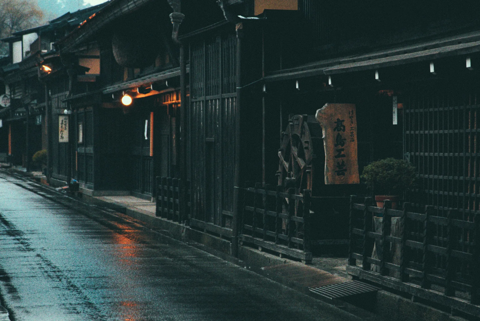 A sake brewery sign above the wet street of the old town