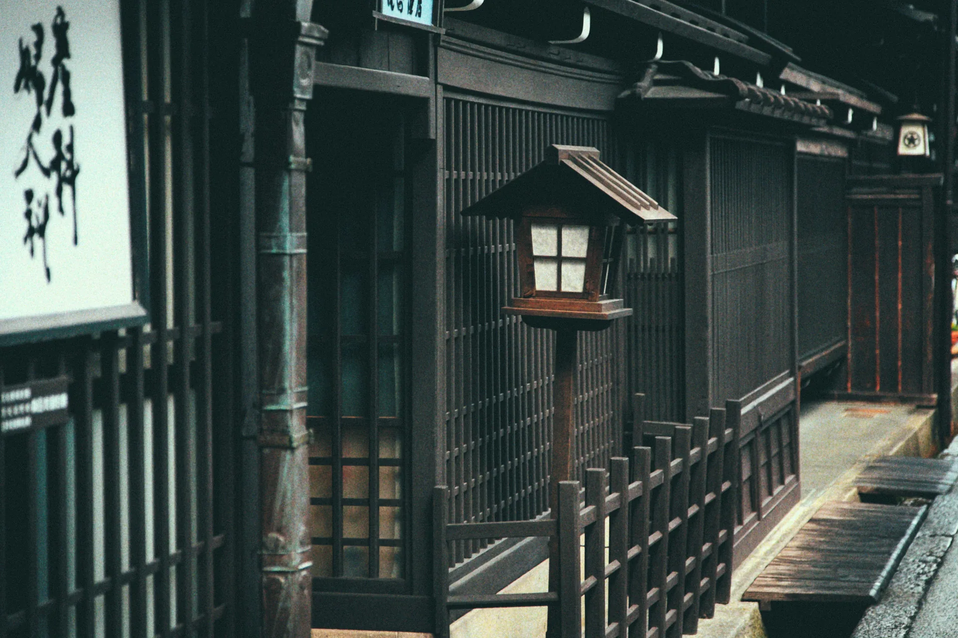 A wooden street lantern outside a doll shop