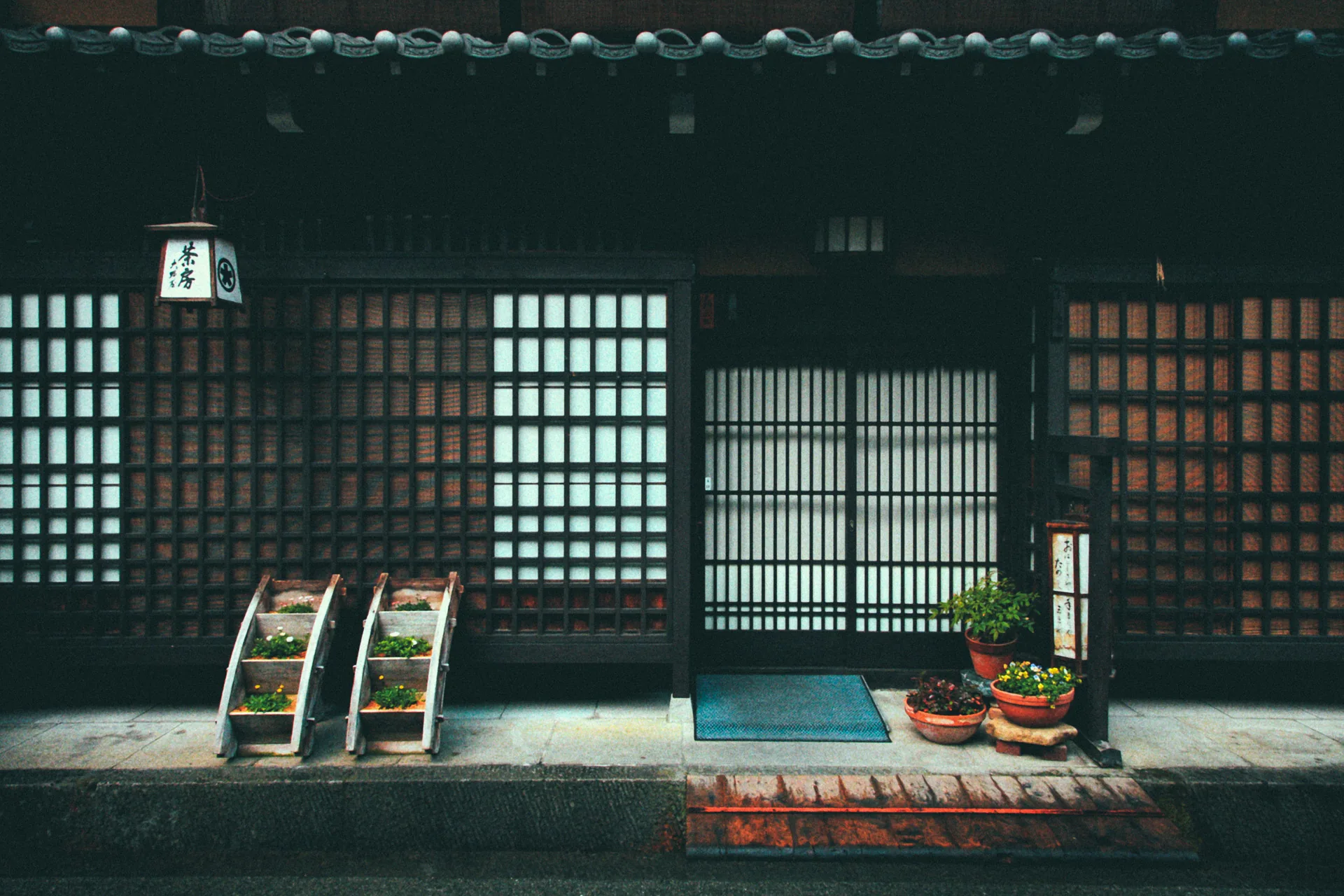 A latticed entrance with potted plants and a small lantern