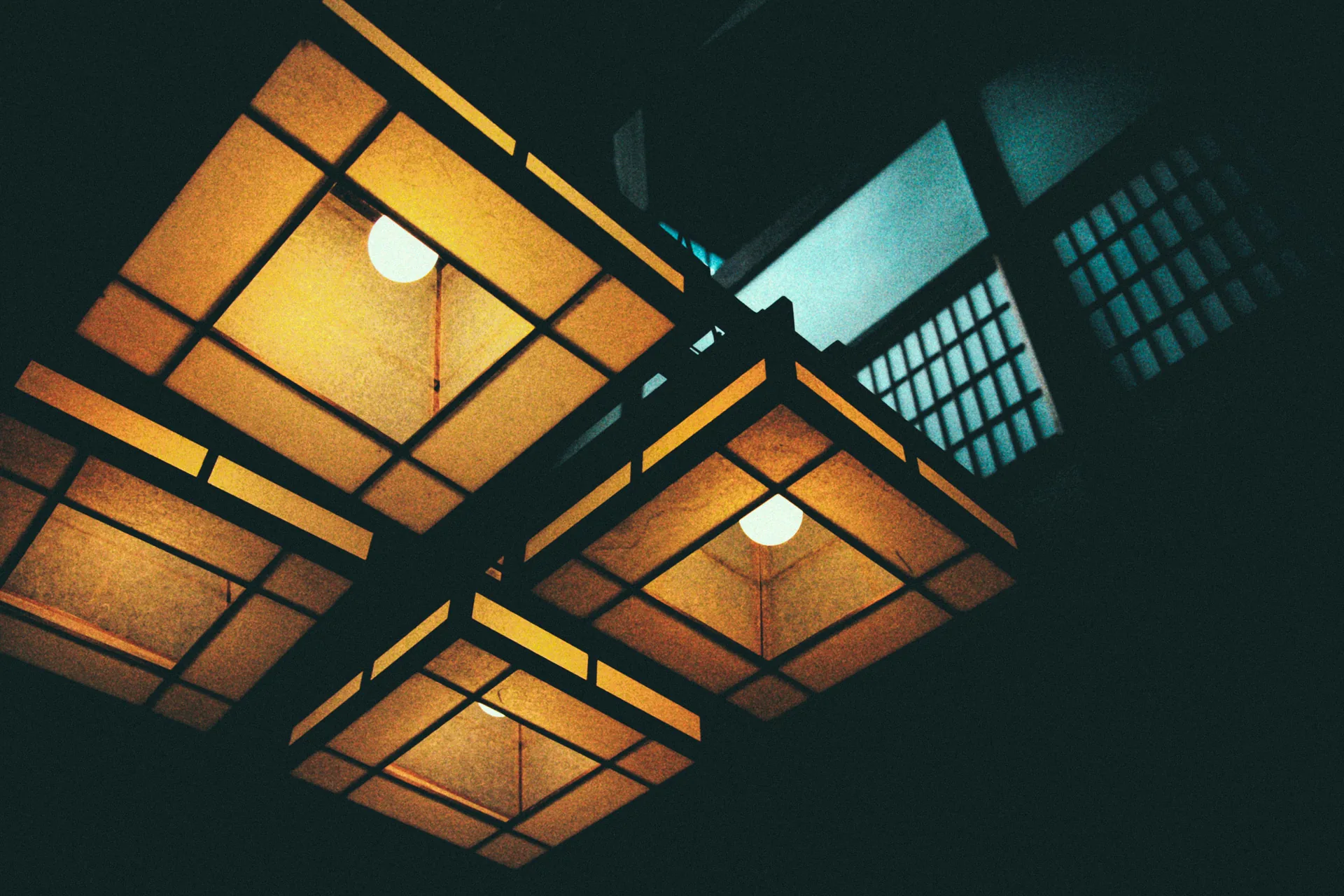 Glowing paper lamps hanging under a wooden ceiling