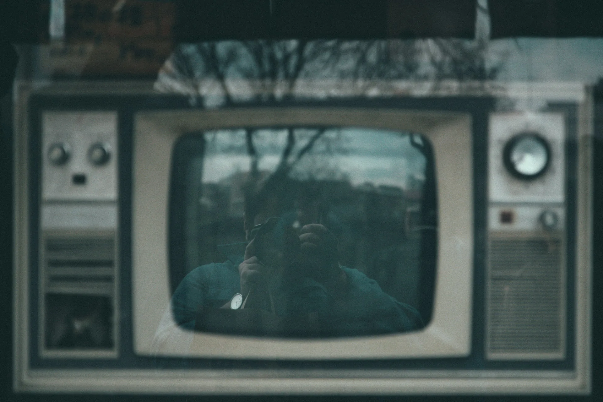 An old television set reflecting the photographer in its screen