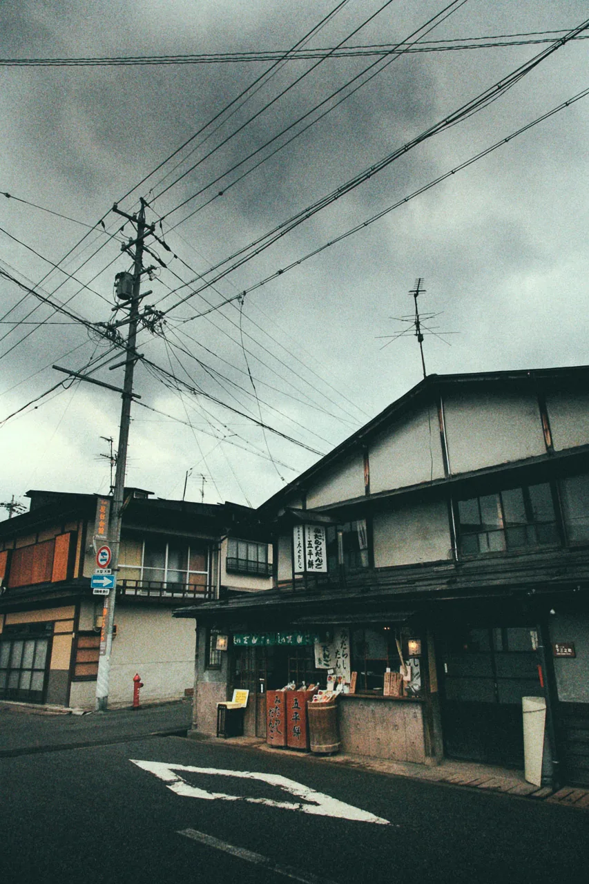 Power lines over an old street corner under a cloudy sky