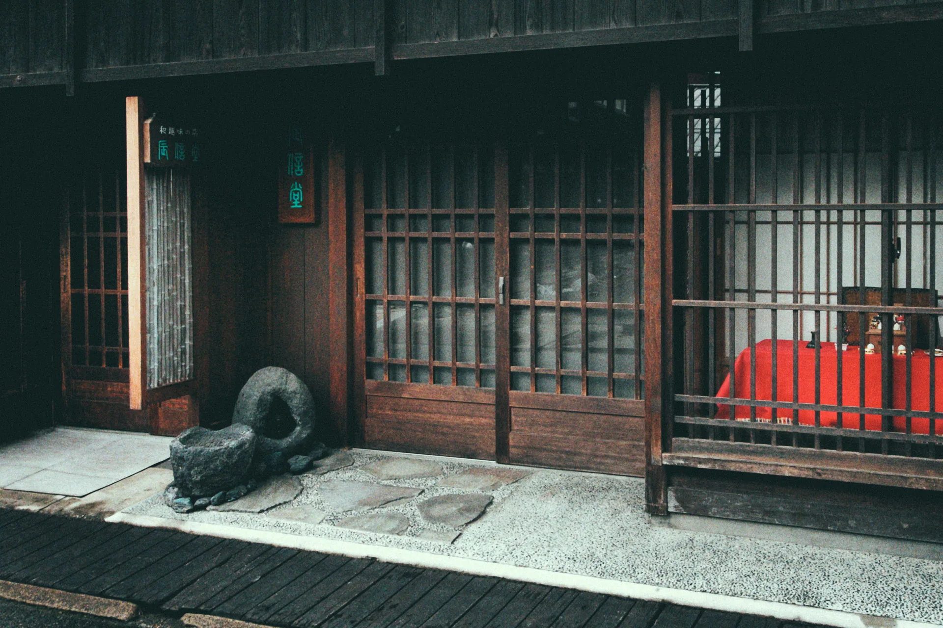 A latticed house with a stone frog by the door