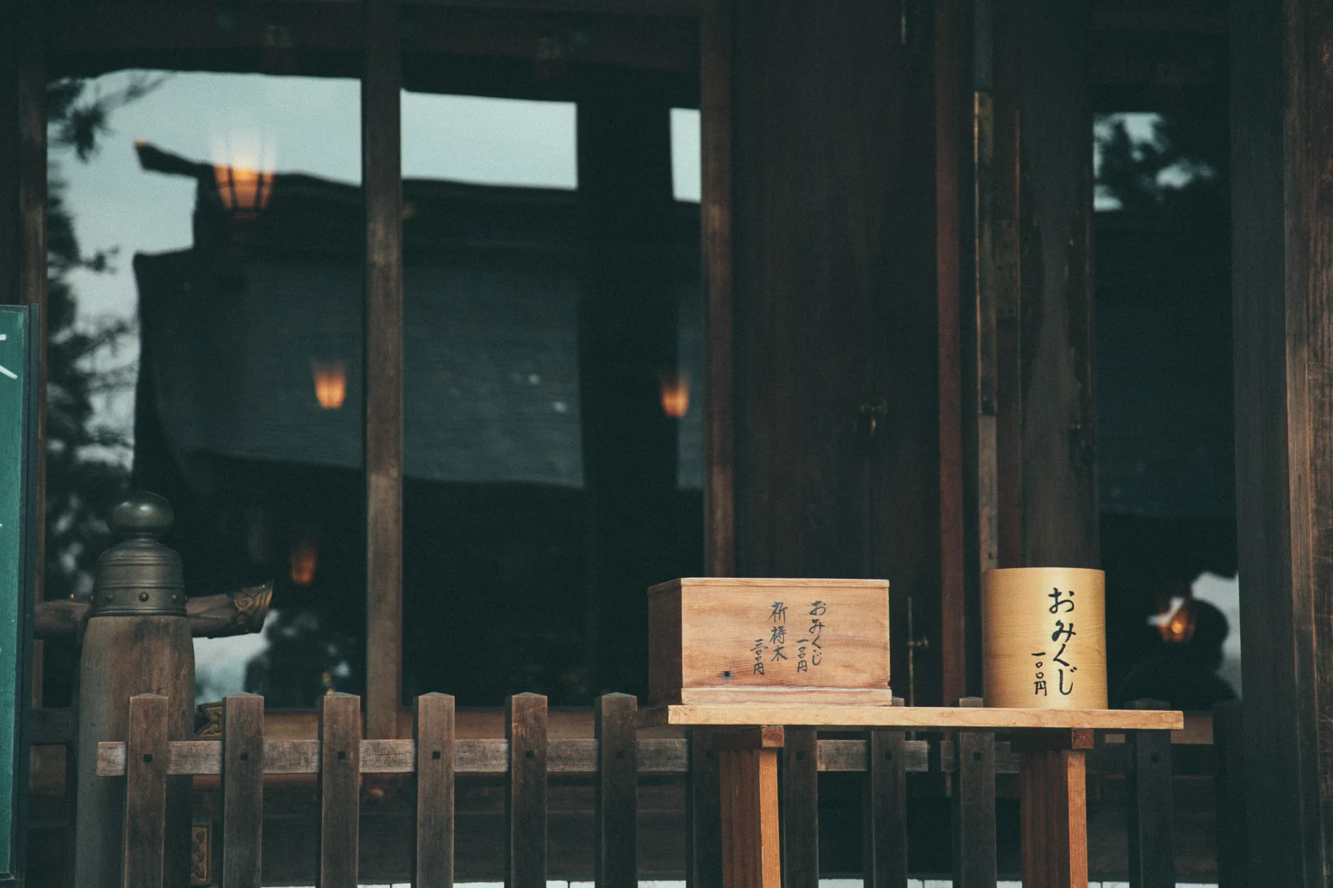 An omikuji stand inside a dark shrine hall