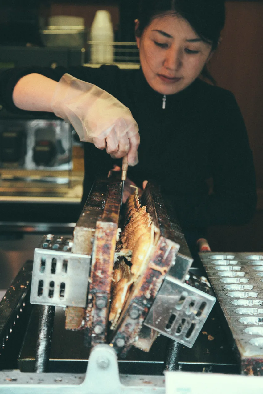Turning the taiyaki moulds over the grill
