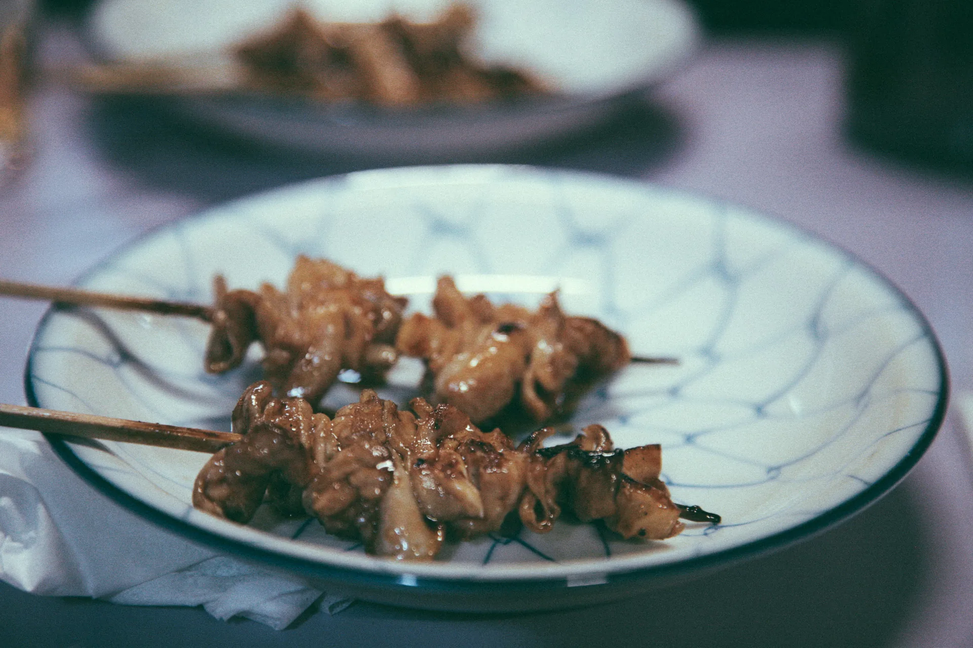 Chicken skewers on a blue-and-white plate